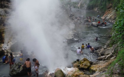 川の中で温泉に浸かる市民ら